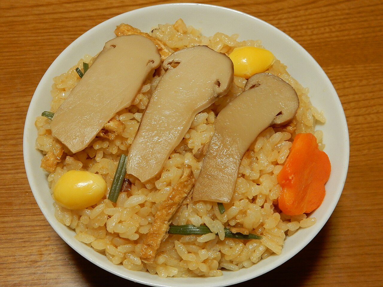 真实松茸饭料理摄影，米饭上摆有松茸切片